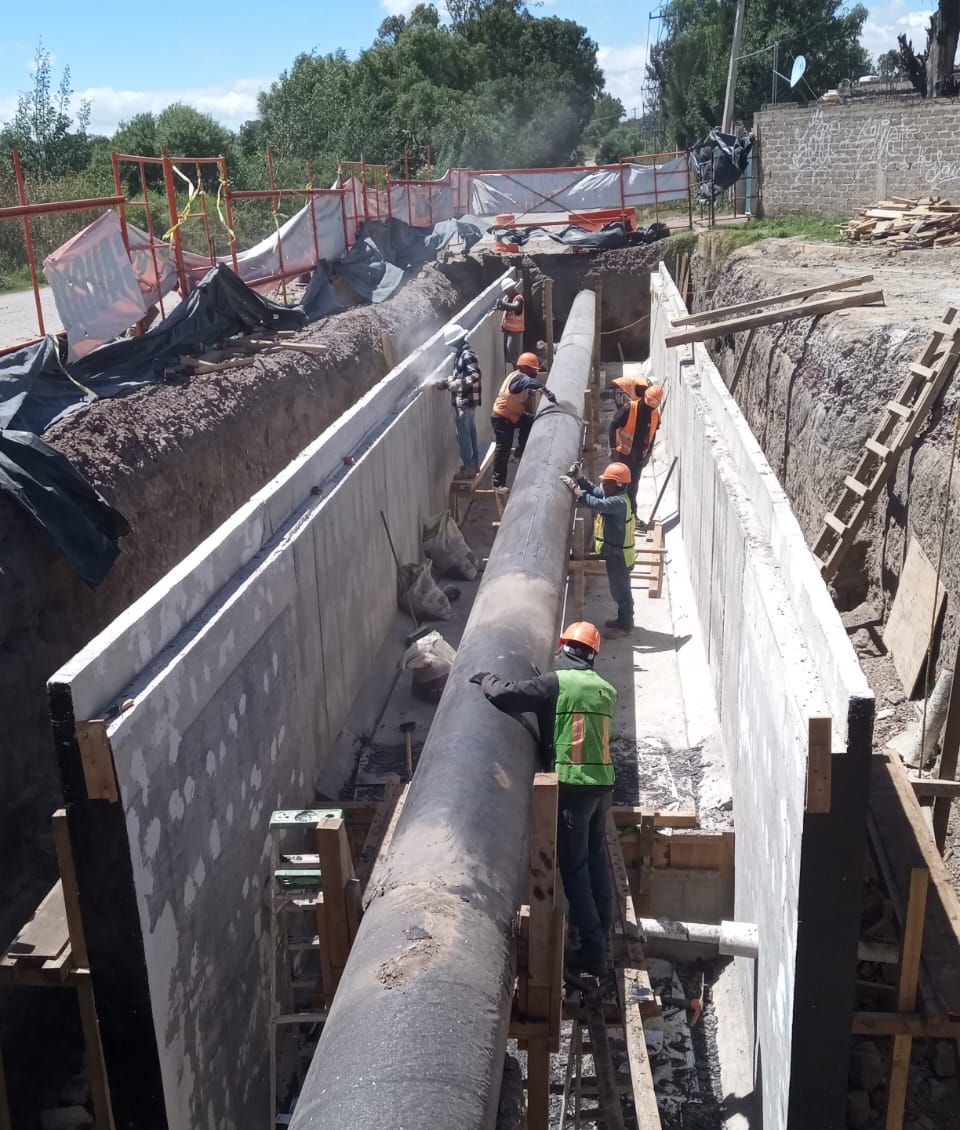 Trinchera con muros de concreto a ambos lados de un ducto