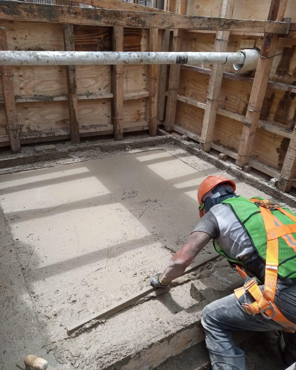 Trabajador nivelando concreto fresco dentro de la cimbra