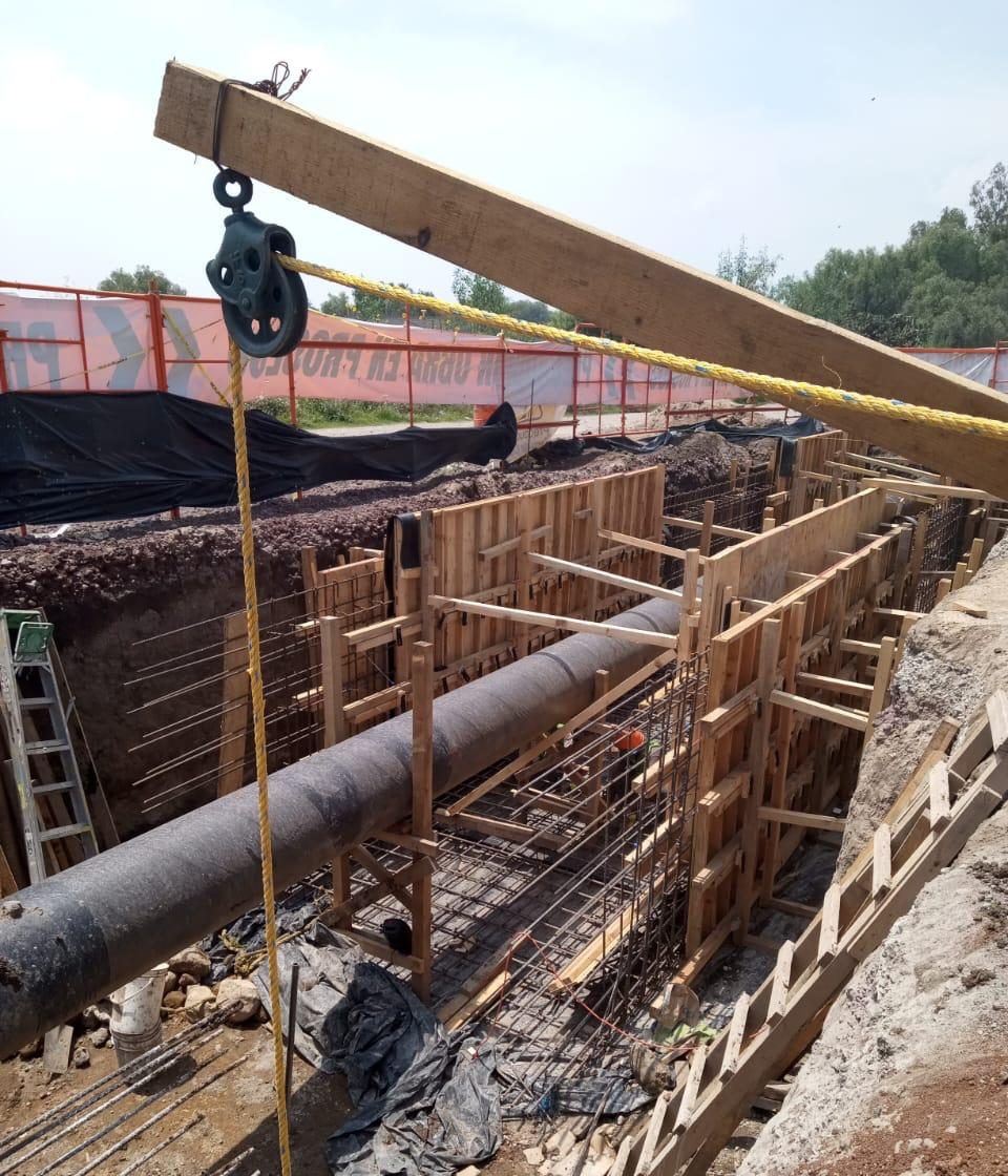 Cimbra de madera y acero de refuerzo alrededor de un ducto en trinchera